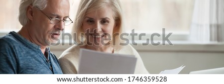 Elderly spouses read paper from bank, analyzing financial statement manage together family budget feels satisfied, enough money, taxes refund concept. Horizontal photo banner for website header design Royalty-Free Stock Photo #1746359528