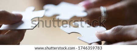 Close up photo hands of multi ethnic people hold diverse pieces of puzzle, team assembling jigsaw joining fragments, teamwork, search find solution concept. Horizontal banner for website header design Royalty-Free Stock Photo #1746359783