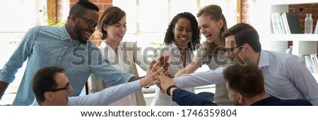 Happy multi ethnic colleagues celebrating business success giving high five show support share common victory. Teambuilding, teamwork, unity concept. Horizontal photo banner for website header design