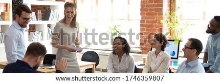 Multi ethnic business team having fun at group meeting. Participation at team building, employees laughing at briefing or corporate training concept. Horizontal photo banner for website header design Royalty-Free Stock Photo #1746359807