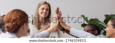 Diverse excited teammates giving high five celebrate common achievements, corporate success gathered at group meeting, team building activity concept. Horizontal photo banner for website header design Royalty-Free Stock Photo #1746359813