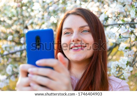 Beautiful young woman taking selfie outdoors on sunny day