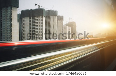 High-speed rail running on train, cities and buildings outside windows produce motion blurring effects. Industrial landscape. Railway tourism. 