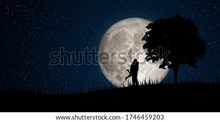 Happy Family Concept : Silhouette of Miniature people as lover standing on little hill with full moon in background. (Elements of this image furnished by NASA.)