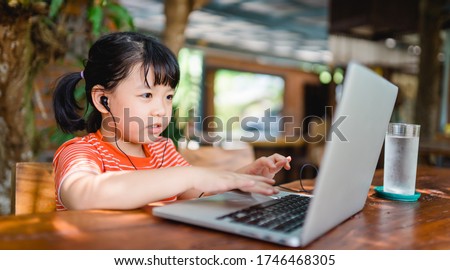 Asian girl student online learning class study online video call zoom teacher, Happy girl learn english language online with laptop at home.New normal.Covid-19 coronavirus.Social distancing.stay home Royalty-Free Stock Photo #1746468305