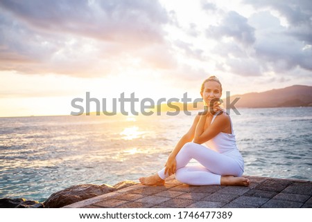 Woman practices yoga at seashore