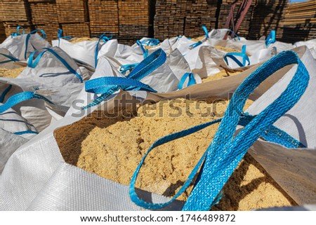 big bags with wood shavings, sawdust. Industrial site of a sawmill. Royalty-Free Stock Photo #1746489872