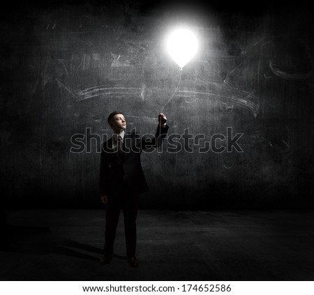 businessman holding flying light bulb