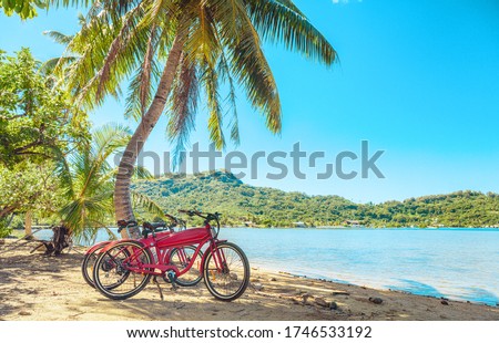 Cycling tourism e-bike bikes biking tour excursion tourists summer vacation travel landscape. Tahiti island bicycles on beach. Royalty-Free Stock Photo #1746533192