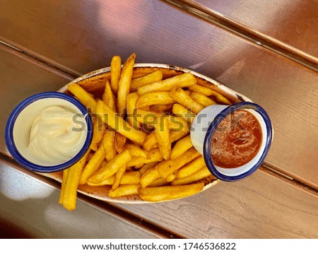 Funny picture from above of French fries and ramekins of Mayonnaise and Ketchup
