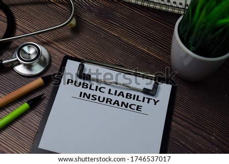 Public Liability Insurance write on paperwork isolated on wooden table.