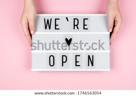 Lightbox with the text WE OPENED on a pink background in the hands of women. The owner of the hotel, beauty salon, restaurant informs customers about the opening Royalty-Free Stock Photo #1746563054