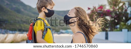 Mother puts her child a face protective mask on the street. Stop the infection. Coronavirus quarantine. Apocalypse. Health care concept. Mask against infectious diseases and flu BANNER, LONG FORMAT