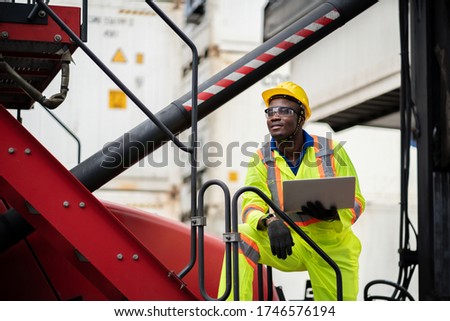 Portrait  engineer man happy worker in protective safety jumpsuit uniform  with hardhat and use laptop computer at cargo container shipping warehouse. transportation import,export logistic industrial