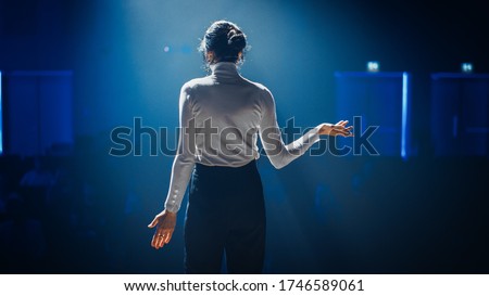 Female Motivational Speaker on Stage, Talking about Happiness, Diversity, Success, Leadership, STEM and How to Be Productive. Woman Presenter Leads Tech Business Conference. Back View Shot Royalty-Free Stock Photo #1746589061