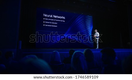 Computer Science Startup Conference: On Stage Speaker Does Presentation of New Product, Talks about Neural Networks, Shows New AI, Big Data and Machine Learning App on Big Screen. Live Event Royalty-Free Stock Photo #1746589109