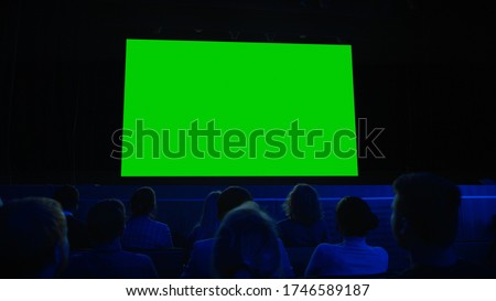 In the Movie Theater Captivated Audience Watching New Blockbuster Film on Mock-up Green Screen. People Watching Video Game Tournament Streaming, Live Concert, New Product Release Trailer