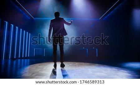 Famous Entertainer Stands on Stage, Greets Audience, Starts Performance. Software Company Founder, Tech Marketing Guru Making a Pitch, Presentation Speaker Giving Talk. Cinematographic Back View