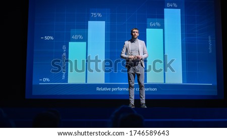 On-Stage: Speaker Does Presentation of the New Electronic Product, Shows Infographics, Statistic Animation on Screen. Auditorium Hall Live Event, Start-up Conference, Device Presentation and Release