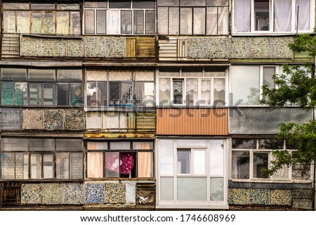 Old windows and balconies. Facade of a dilapidated house of post-Soviet architecture Royalty-Free Stock Photo #1746608969