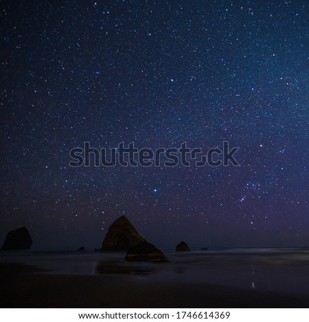 Night beach of the sea or ocean at sunset. Rocks in the water. Night night sky.