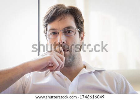 Man looking directly at the camera making a conference call, making home office.