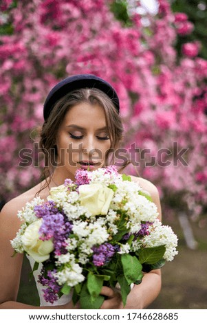 A woman holding a pink flower on a plant. High quality photo