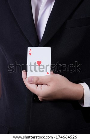 business man holding playing card on black background