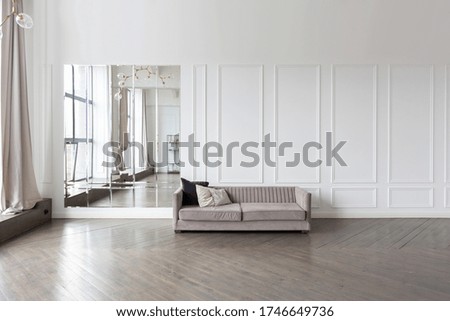 Modern luxury stylish apartment interior in pastel colors. a very bright room with huge windows filled with daylight. white walls, wooden parquet floors.
