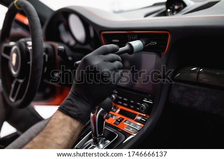 A man cleaning car interior, car detailing (or valeting) concept. Selective focus.   Royalty-Free Stock Photo #1746666137