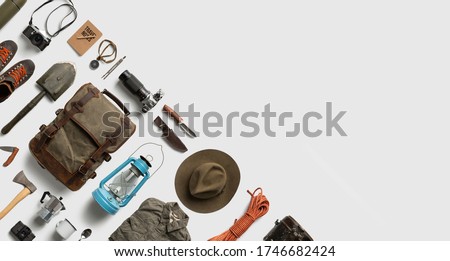 Top view of hiking and camping items arranged on abstract white background. Flat lay with copy space. Royalty-Free Stock Photo #1746682424