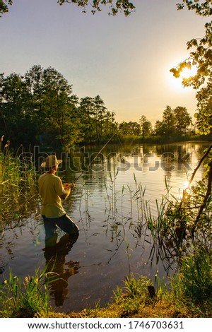 angler catching the fish during sunny day
