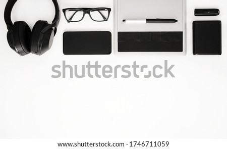Top view office table desk. Workspace with headphones, glasses, mobile phone, tablet, flash drive and powerbank. Copy space.