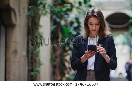  hipster girl reading text business message from her managers connected to public internet outdoors, beautiful professional woman chatting on smartphone while relaxing outdoors