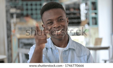 Portrait of Happy Young African Man Pointing with Finger