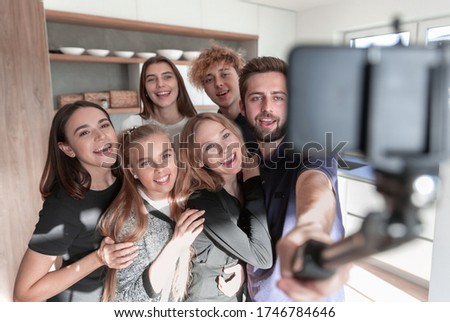 Image of happy young friends at home take a selfie by camera