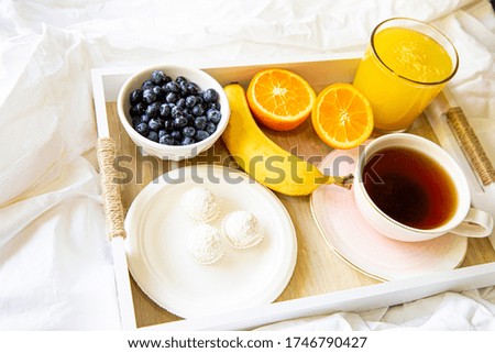 continental breakfast: coffee, orange, juice, blueberry, banana and coconut candies in bed,  Healthy yummy and beautiful food