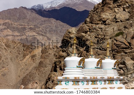 Three White-Gold Stupas with Rock Mountain Background