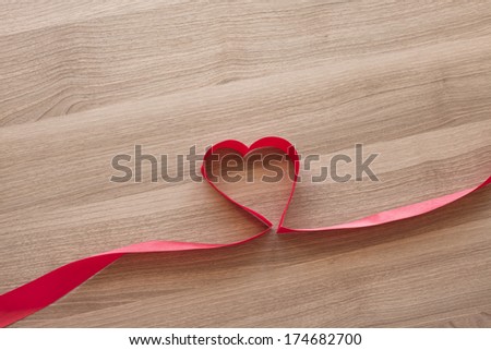 Photo background: heart and ribbon on a wooden background texture.