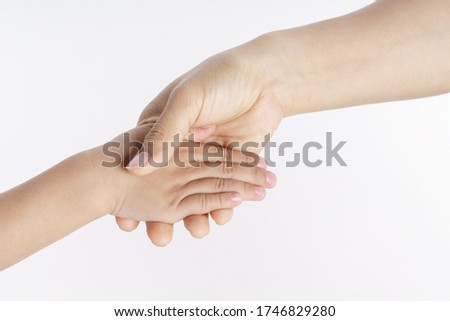 Mother holding her kid hand as a support gesture on white background