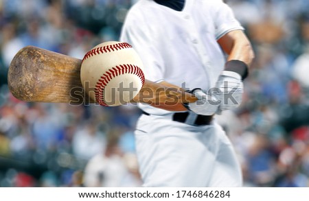 Baseball player hitting ball with bat in close up 