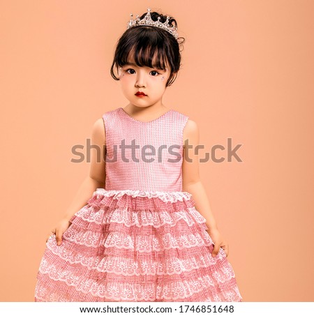 Cute Asian little princess in a pink dress
