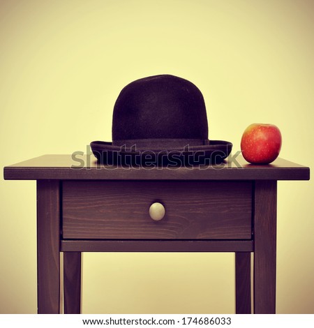 picture of a bowler hat and an apple on a bureau, homage to Rene Magritte painting The Son of Man, with a retro effect Royalty-Free Stock Photo #174686033