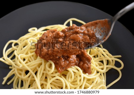 Spaghetti Bolognese with minced beef, onion, chopped tomato, garlic, olive oil, stock cube, tomato puree and Italian herb. Traditional Italian food with a spoon.  Selective focus. 