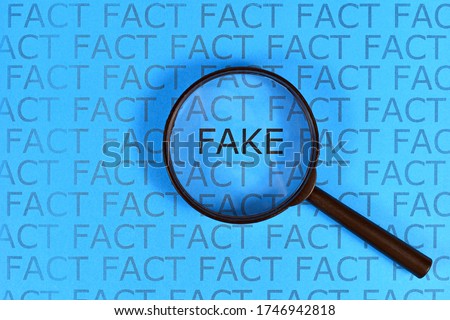 Fake News concept with words 'fact' in row and single word  'fake' highlighted by magnifying glass on blue background Royalty-Free Stock Photo #1746942818