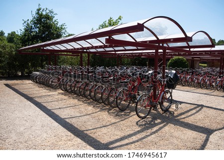 Hundreds of red bicycles in the bicycle shed