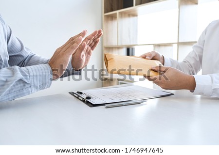 Anti bribery and corruption concept, Business man refusing and don't receive money banknote in envelope offer from business people to accept agreement contract of investment deal. Royalty-Free Stock Photo #1746947645