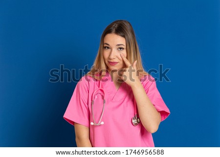 Blonde doctor with pink uniform on a blue background
