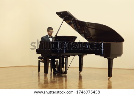 Pianist playing a grand piano in a salon isolated on white background