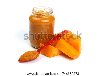 Pumpkin porridge in a spoon isolated on white, natural baby food